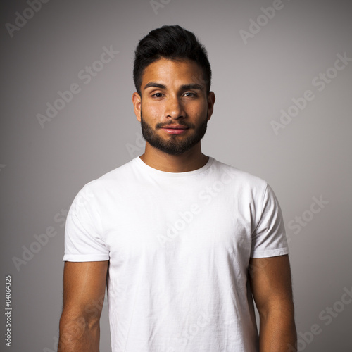 Joven latino con barba y camiseta blanca en plano medio photo