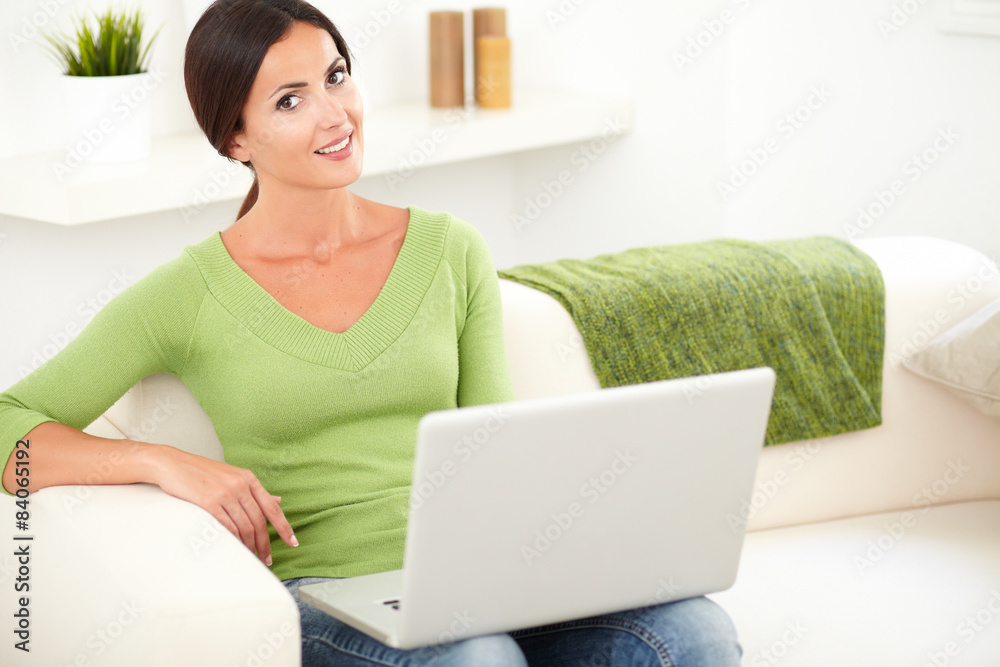 Smiling lady holding a laptop indoors Smiling lady holding a laptop indoors