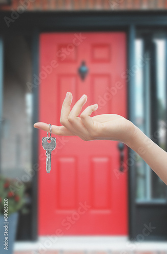 Mano con chiave sfondo porta rossa di casa photo