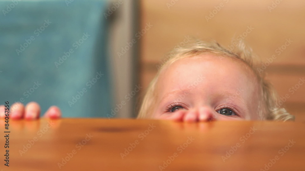 A girl watches her mother stir a bowl full of cake batter