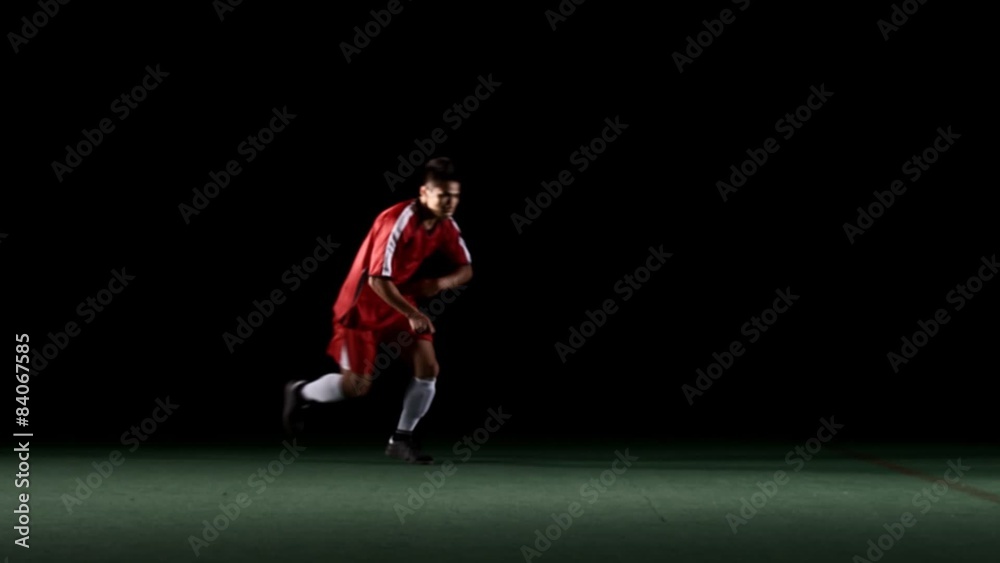 A soccer player approaching the ball from off screen and kicking it with power A soccer player approaching the ball from off screen and kicking it with power