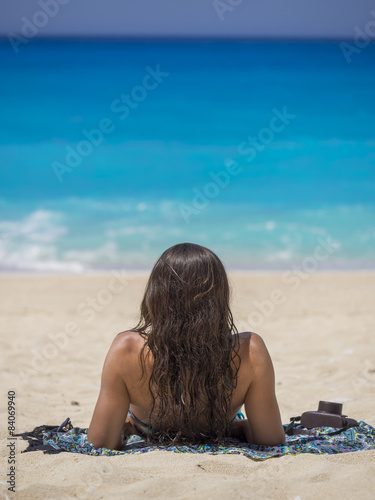 Woman relaxing on the famous Shipwreck beach in Zakynthos © Netfalls