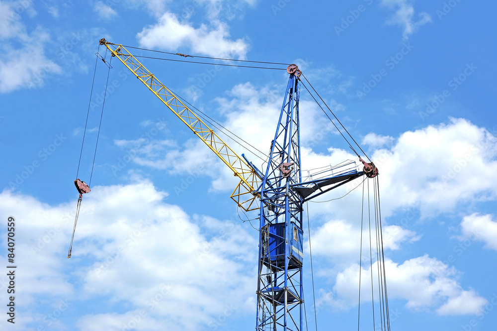 Old construction tower crane against blue sky