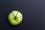 green apple cutting in the shape of pie chart on back board