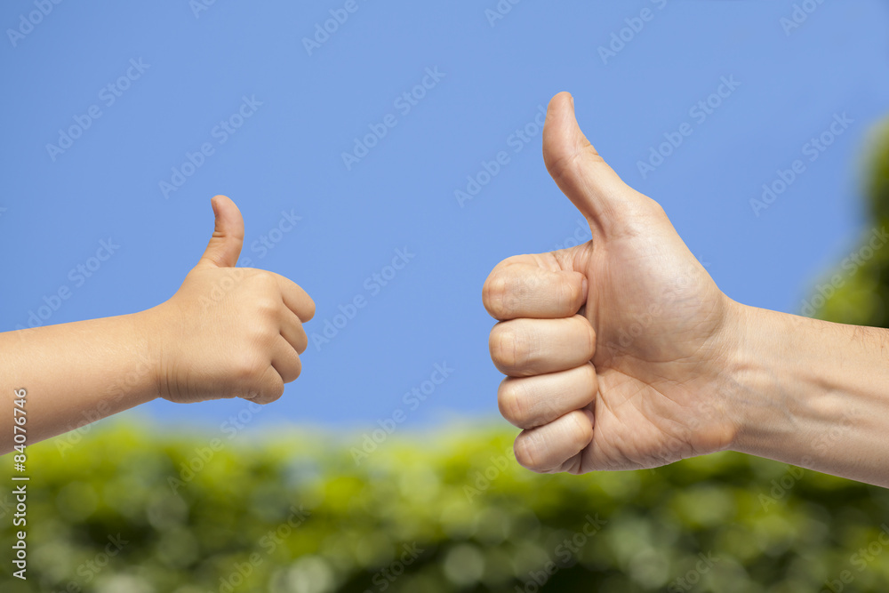father and son hands giving like on sky background father and son hands giving like on sky background