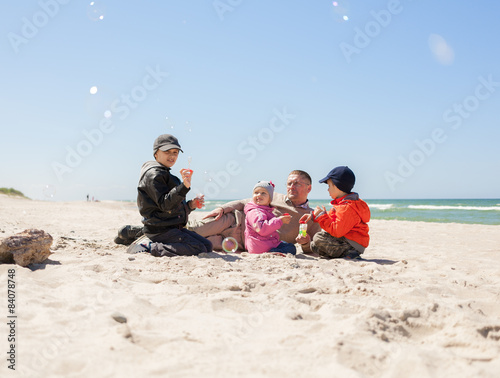 family on beach,  father of many children, kids blowing bubbles 