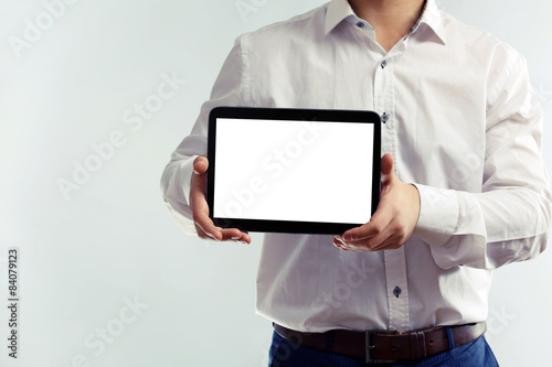 Man holding tablet on grey background