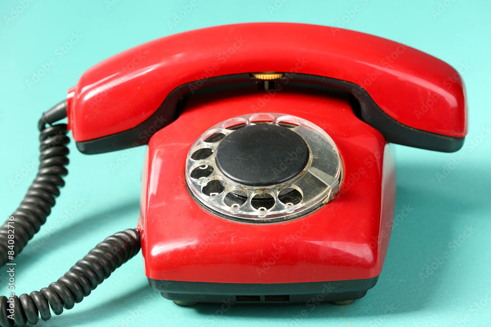 Retro red telephone on table on green background Retro red telephone on table on green background