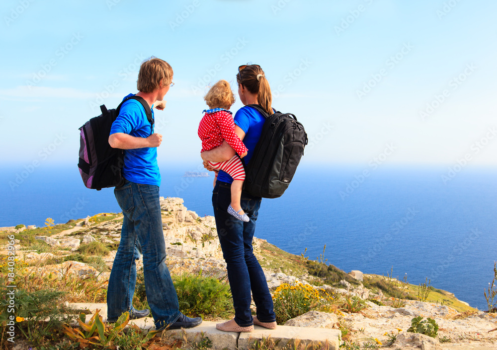 family with little baby hiking in summer mountains