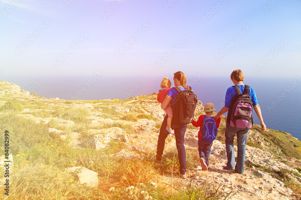 family with kids hiking in summer mountains