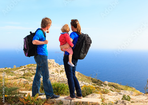 family with little baby hiking in summer mountains