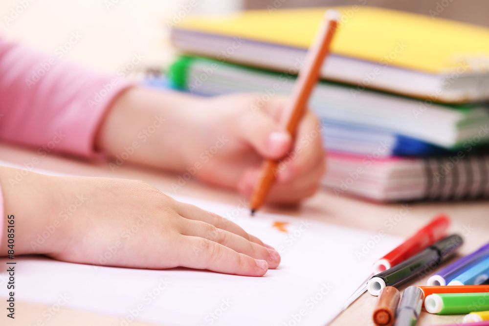 Kids hands drawing on notebook at desktop, closeup Kids hands drawing on notebook at desktop, closeup