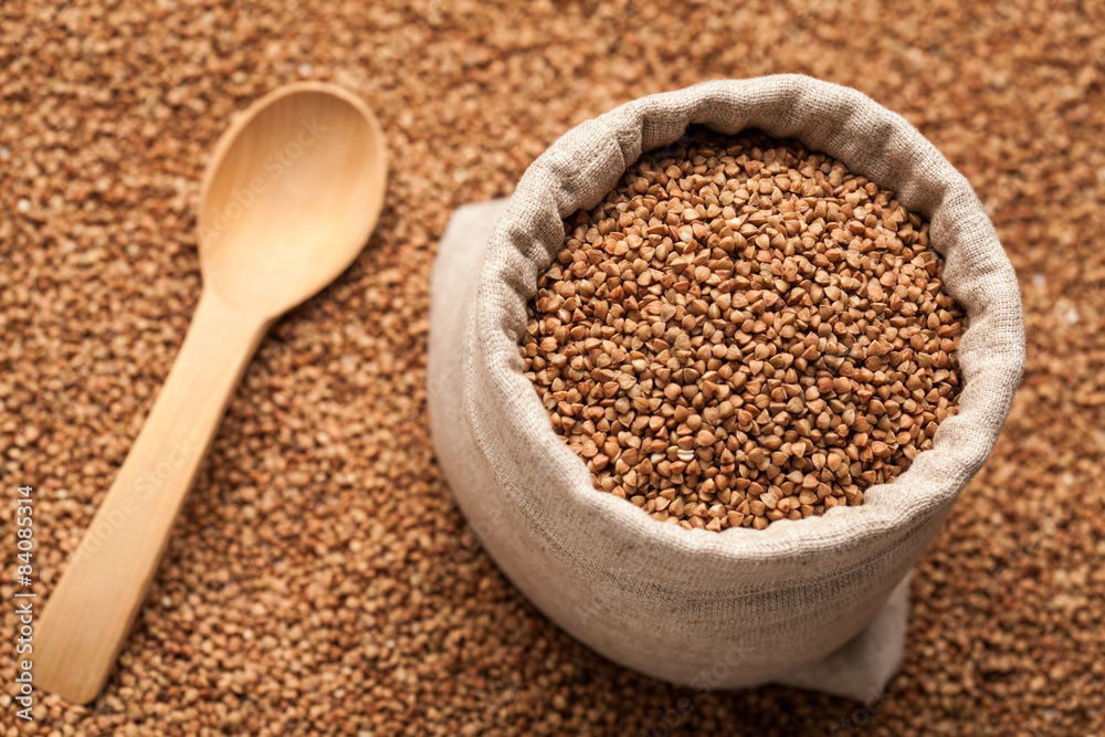 Buckwheat in linen sack with wooden spoon. Buckwheat in linen sack with wooden spoon.