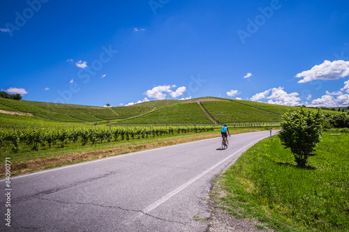 Ciclista pedala su strada nelle colline delle langhe