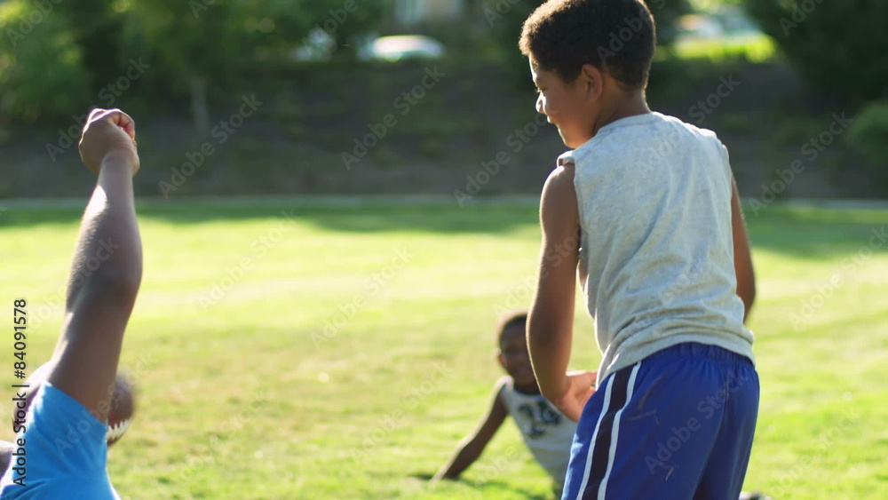 A father plays football with his family, and wrestles with them on the grass A father plays football with his family, and wrestles with them on the grass