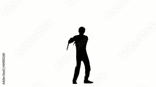 young man expertly twirling nunchaku, silhouette 