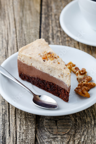 Tasty nuts cake with cup of coffee on wooden background.