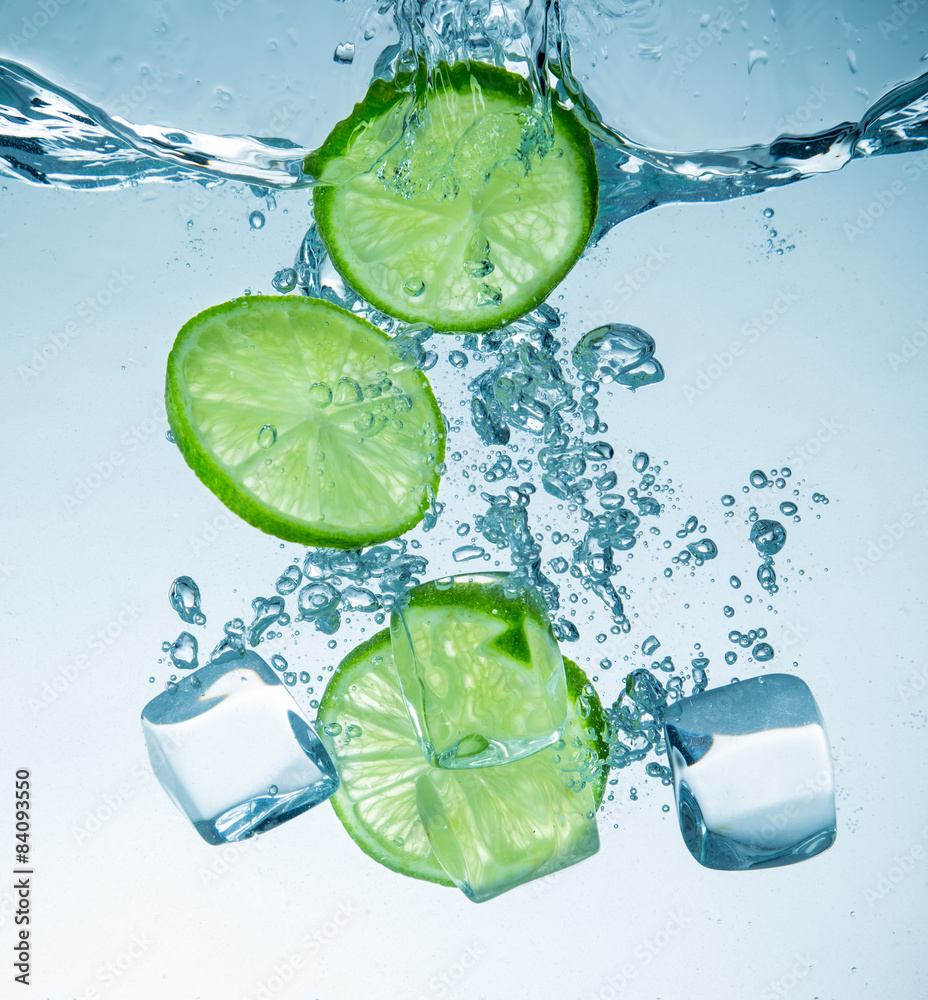 Fototapeta Limes splashing into water