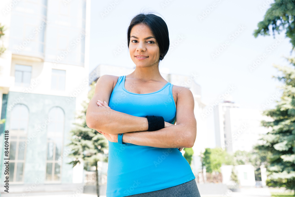 Sports woman standing with arms folded outdoors Sports woman standing with arms folded outdoors