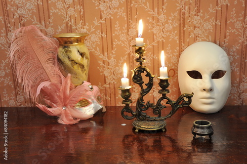 Antique candelabra with three melting candles on an old wallpape