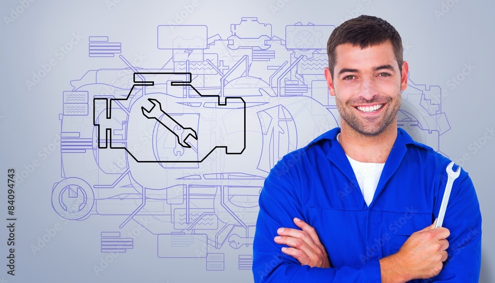 Composite image of smiling male mechanic holding spanner Composite image of smiling male mechanic holding spanner