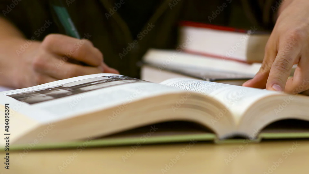 Close up of a student looking through a textbook