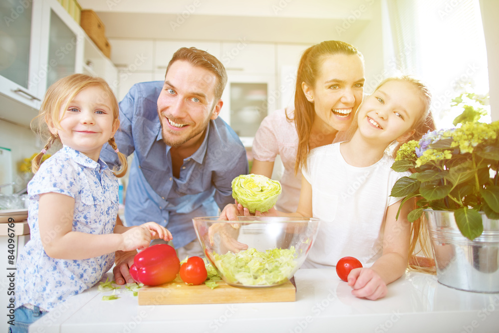 Familie in der Küche macht frischen Salat