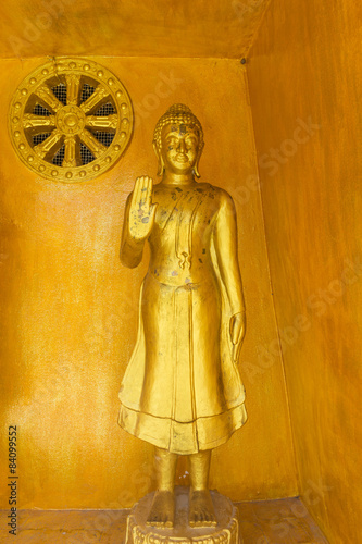 Standing buddha statue  with the gold color background photo