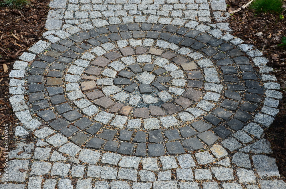 Steinweg mit kreisförmigem Muster aus Pflastersteinen Steinweg mit kreisförmigem Muster aus Pflastersteinen