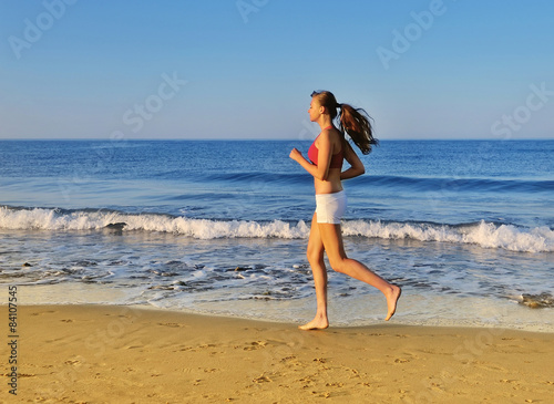 Beautiful girl running on beach at morning