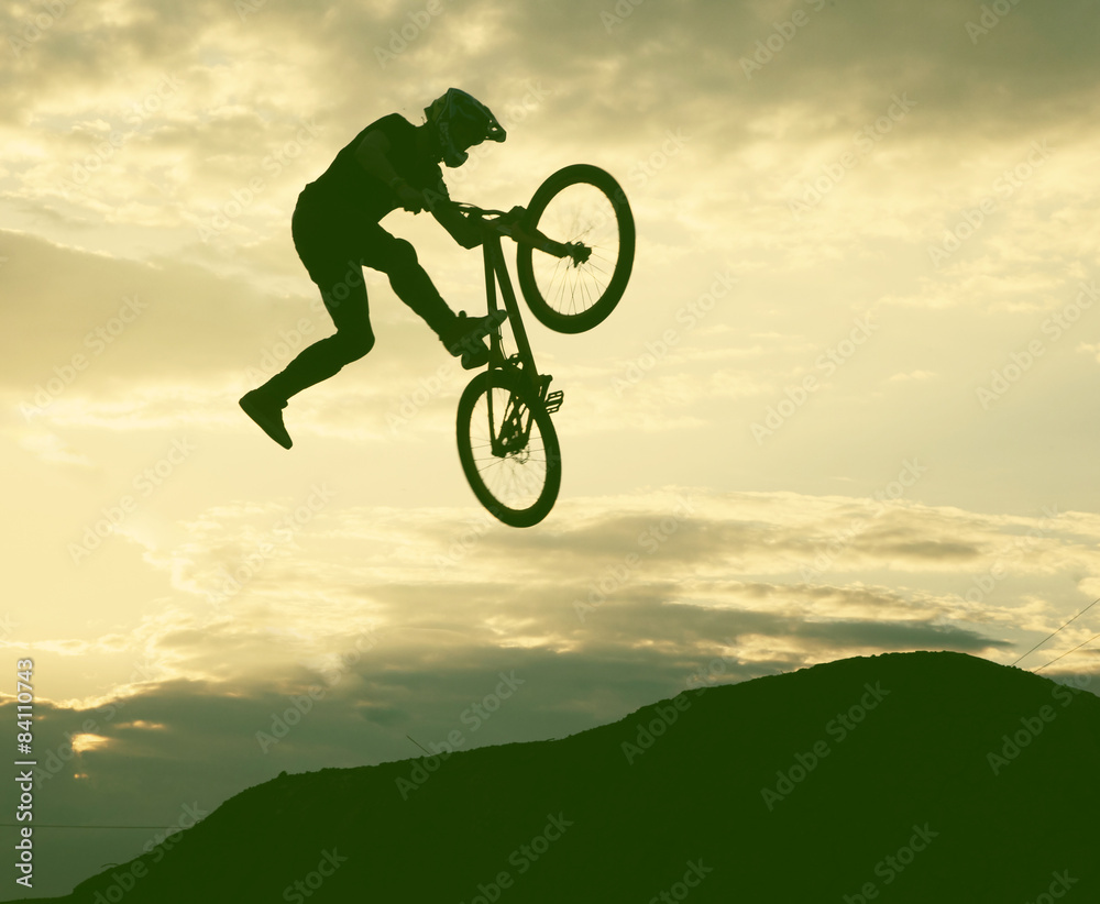 Silhouette of a man doing a jump with a bmx bike against sunset Stock Photo  | Adobe Stock