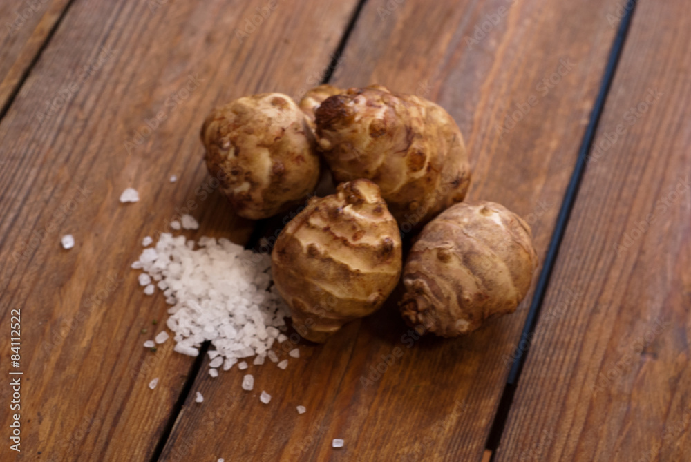 jerusalem artichoke with salt on raw wooden table jerusalem artichoke with salt on raw wooden table
