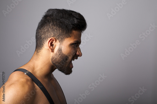 Joven latino con barba de perfil enfadado