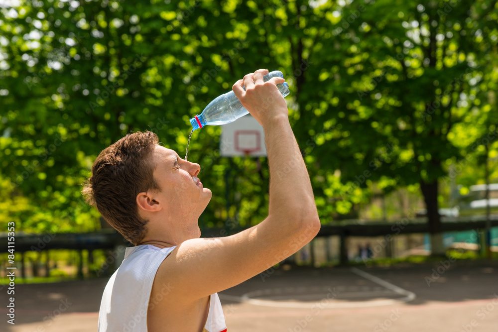 Athletic Man Pouring Water from Bottle onto Face Athletic Man Pouring Water from Bottle onto Face