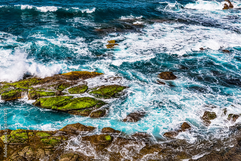 Stones in waves with foam of ocean