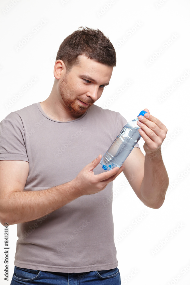 young smiling man carefully consider water bottle young smiling man carefully consider water bottle