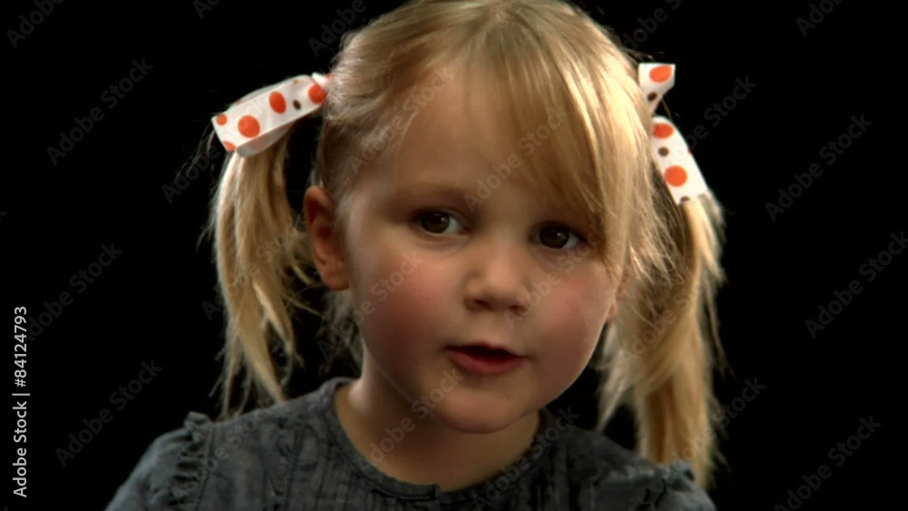A young blonde girl with pigtails blows a kiss A young blonde girl with pigtails blows a kiss