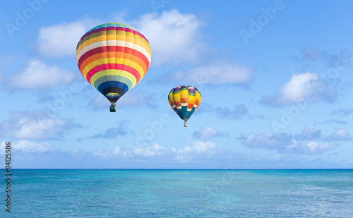 Hot air balloon over ocean and clouds blue sky © littlestocker