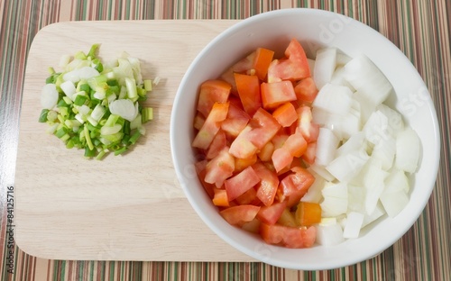 Cutting Board with Chopped Tomatoes, Onions and Spring Onions photo