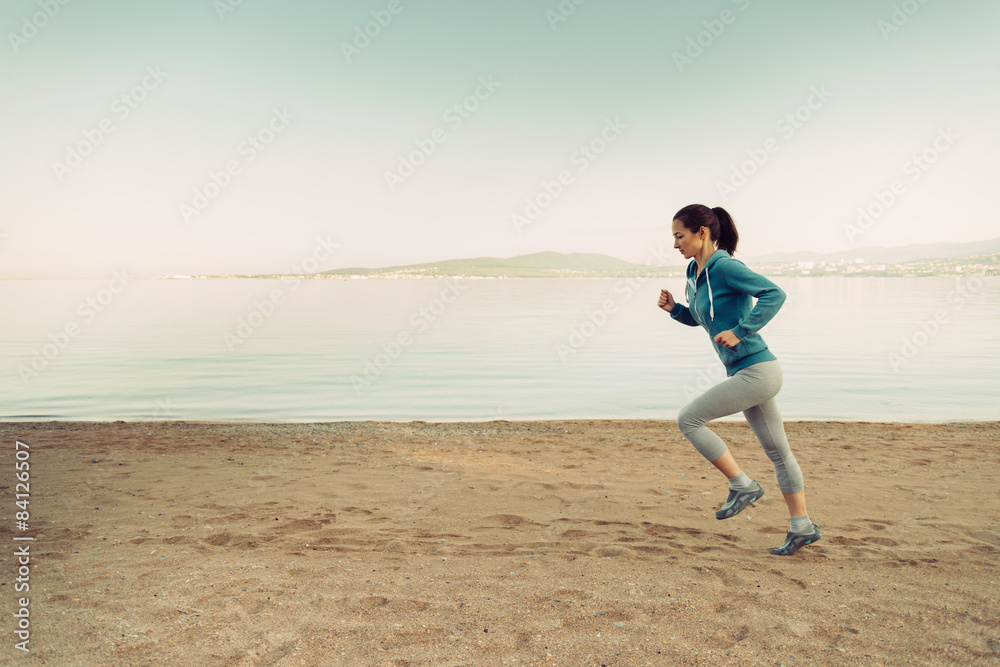 Young woman running on coastline Young woman running on coastline