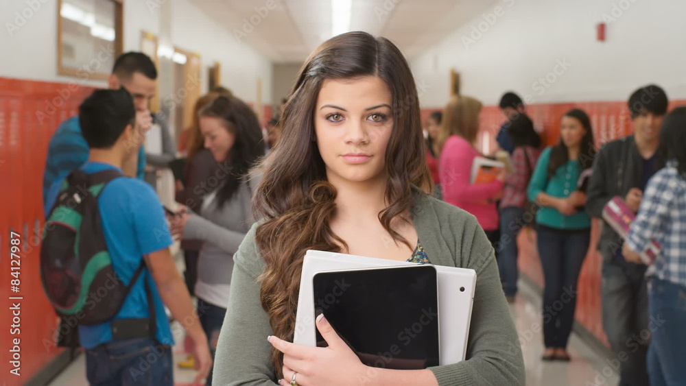 A high school girl stands in the hallway looking at the camera A high school girl stands in the hallway looking at the camera