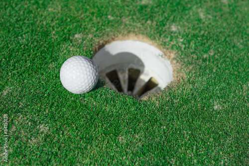 golf ball very close to the hole