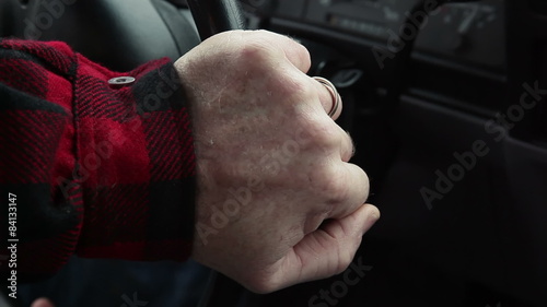 A man driving chooses a radio station to listen to and grabs the wheel and swerves to avoid an accident photo