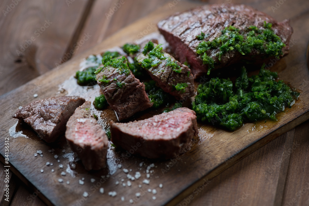 Sliced medium rare grilled beef barbecue steak with chimichurri