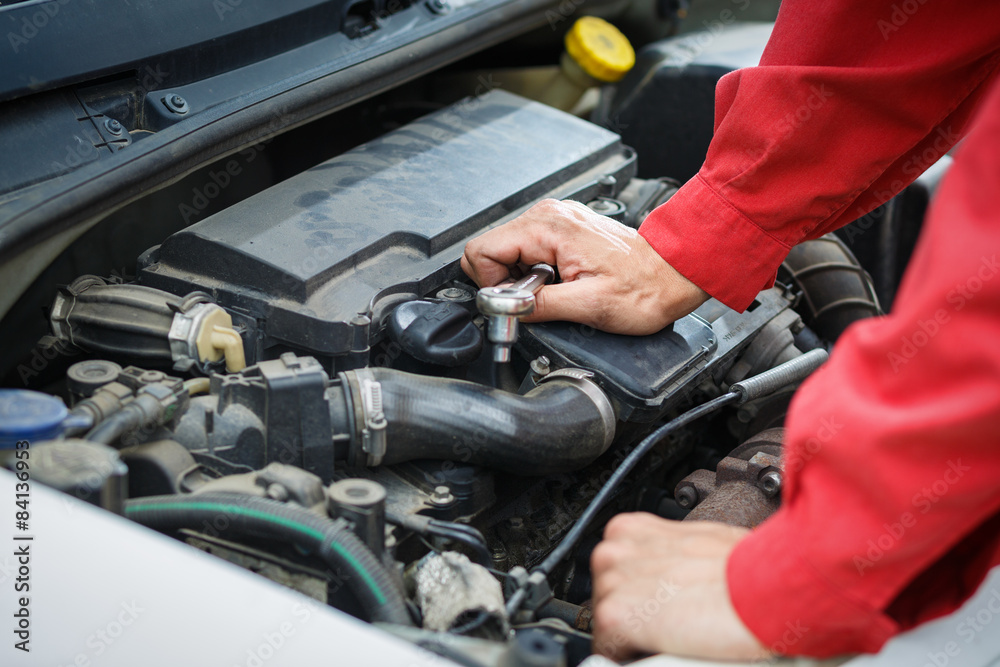 Worker in red overalls working on car car engine Worker in red overalls working on car car engine
