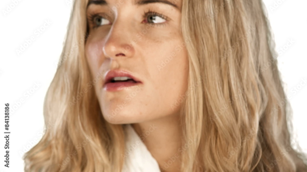 Woman looks with a upset face into the camera on a white background Woman looks with a upset face into the camera on a white background