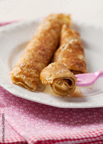 Rolled pancakes with honey, sugar and cinnamon.  photo