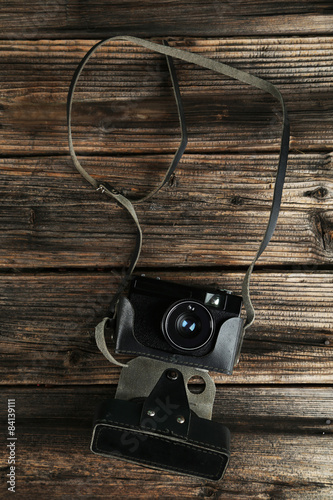 Old retro camera on brown wooden background