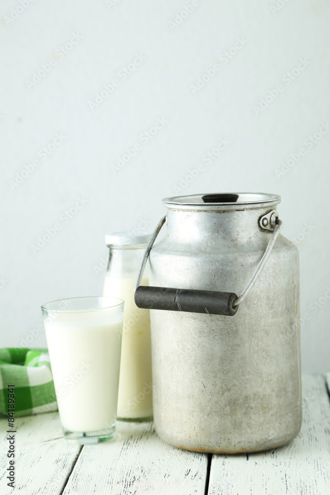 Can and glass of milk on white wooden background Can and glass of milk on white wooden background