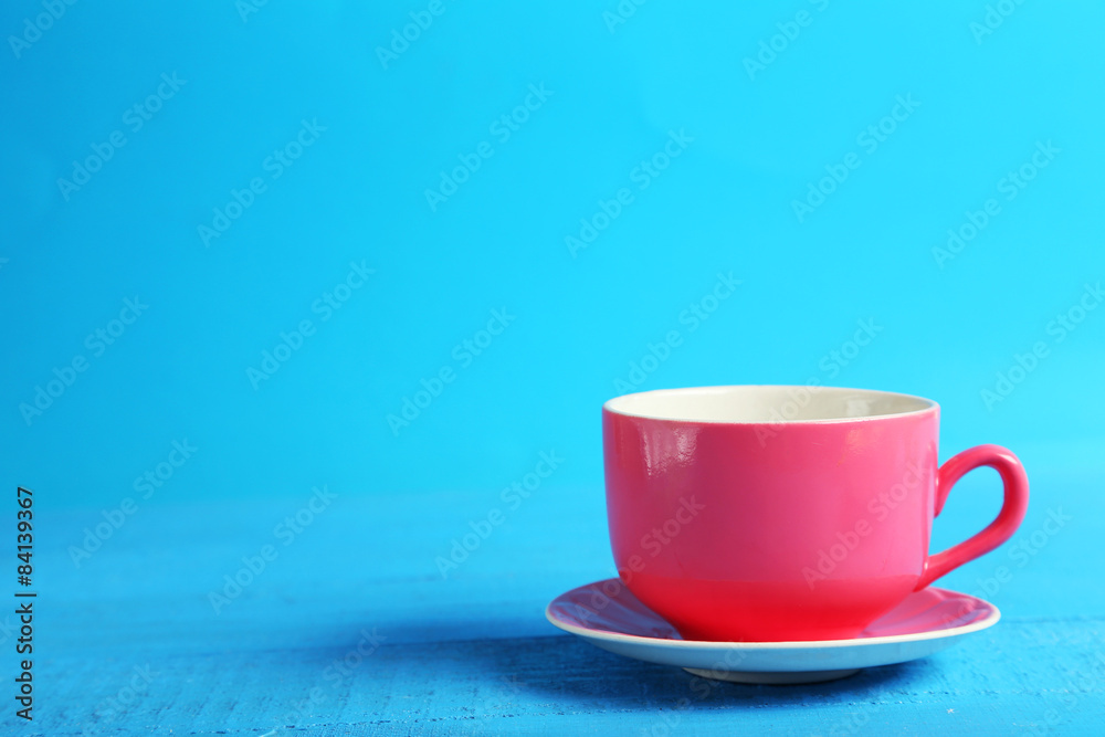 Obraz premium Pink cup on blue wooden background